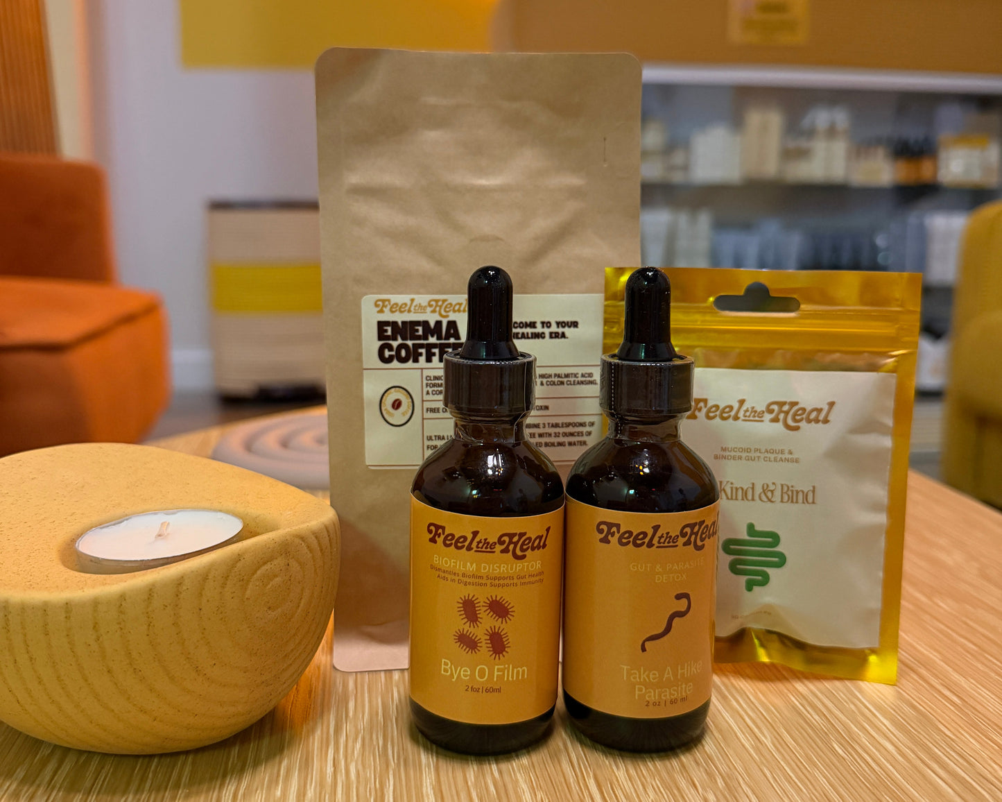 Two bottles of 'Feel the Heal' products on a table with a neon sign in the background.