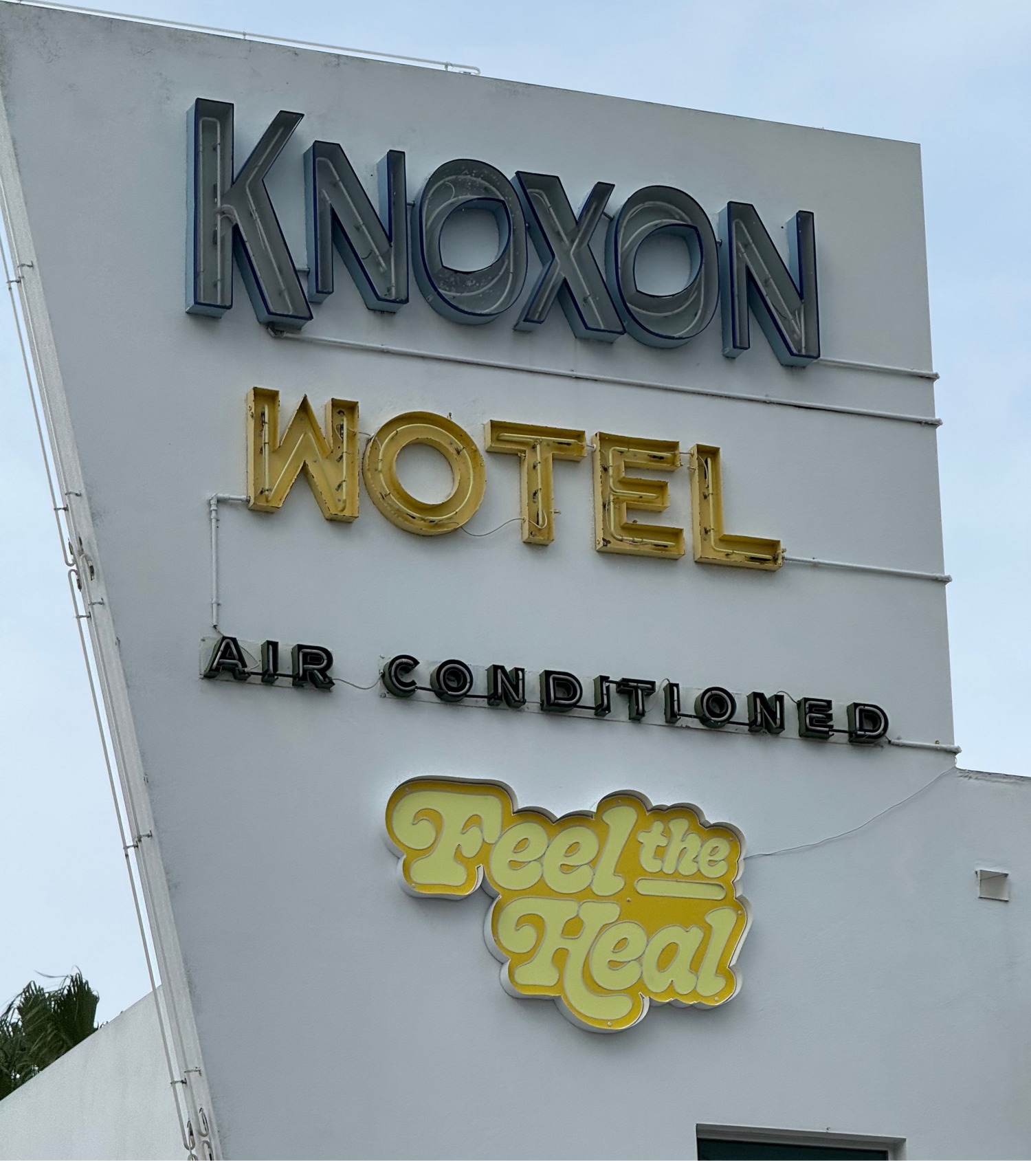 Knoxon Hotel sign with 'Feel the Heat' slogan on a building exterior.