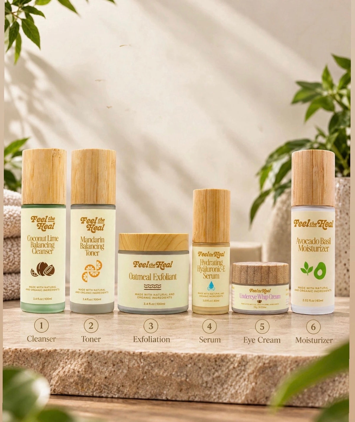 Six skincare products from the brand Peony Royal are arranged on a stone slab with a soft, sunlit background and blurred green leaves. The products include a coconut lime balancing cleanser, satin balance toner, oatmeal exfoliant, hydrating serum, eye cream, and avocado seed moisturizer, all with bamboo caps.