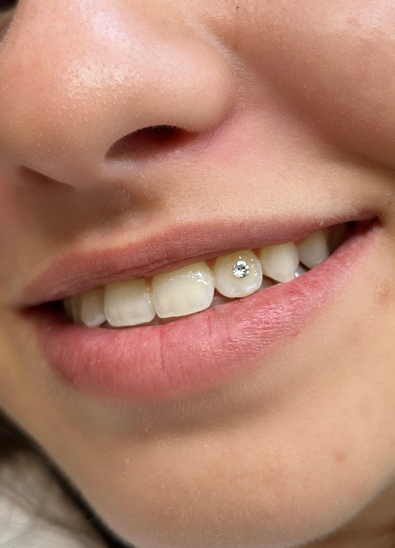 Close-up of a person's mouth with a diamond-studded lip ring.
